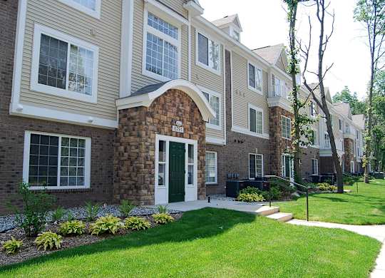Apartment building with a green lawn in front at Tall Oaks Apartment Homes, Kalamazoo, MI, 49009