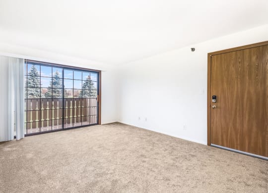 an empty living room with a door to a balcony at Tanglewood Apartments, Wisconsin, 53154