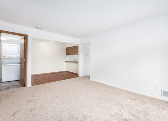 an empty living room with an open door to a laundry room at Tanglewood Apartments, Oak Creek