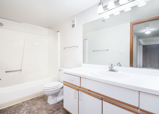 a bathroom with a sink toilet and a mirror at Tanglewood Apartments, Oak Creek, Wisconsin