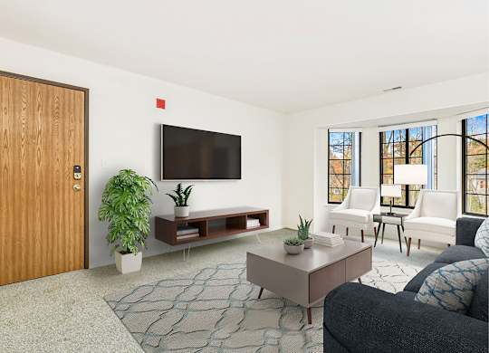 A living room with bay windows, a grey couch, a television, and a rug at Tanglewood Apartments, Oak Creek