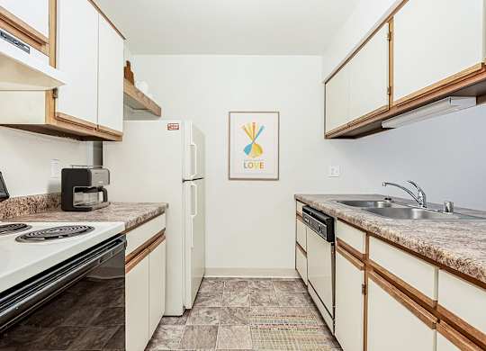 A galley style kitchen with a dishwasher at Tanglewood Apartments, Oak Creek