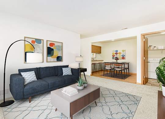 A living and dining room with a couch, table, and a rug at Tanglewood Apartments, Oak Creek
