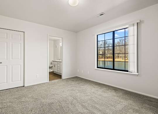 A bedroom with an attached bathroom and a closet at Tanglewood Apartments, Oak Creek, WI
