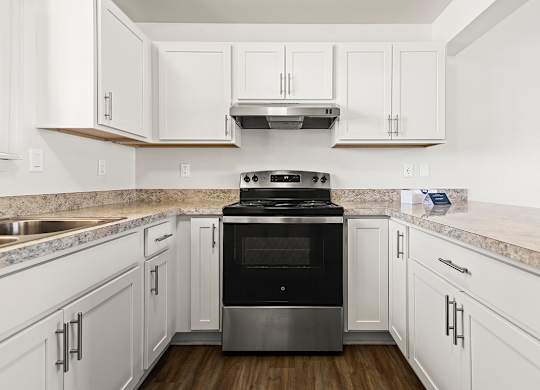 A modern kitchen with white, shaker-style cabinets and a stainless steel oven at Tanglewood Apartments, Oak Creek, WI