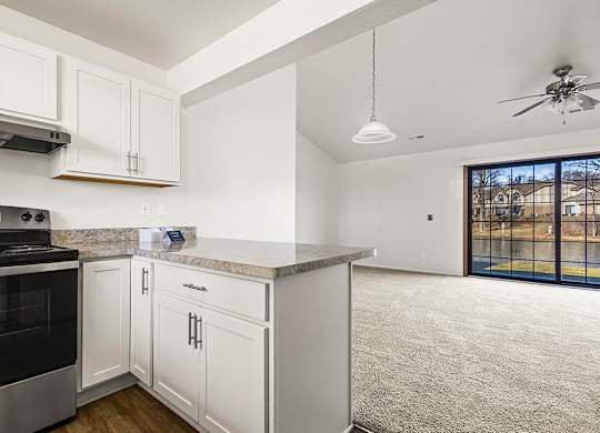 A kitchen with white cabinets and a breakfast bar at Tanglewood Apartments, Oak Creek, WI