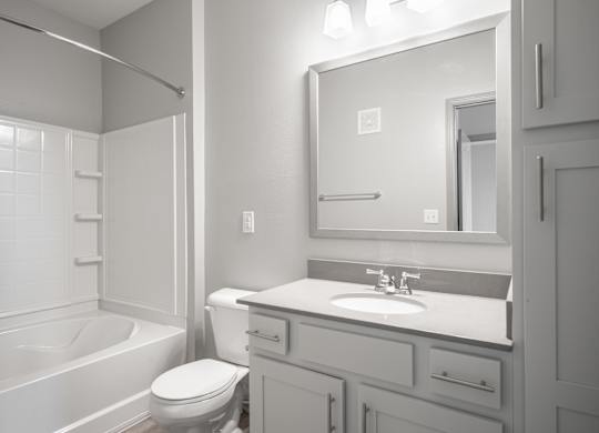 A bathroom with a white toilet, sink, and bathtub.