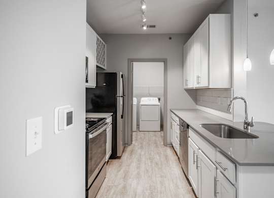 A modern kitchen with a black refrigerator and stove.