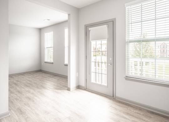 A room with a white door and a window with blinds.