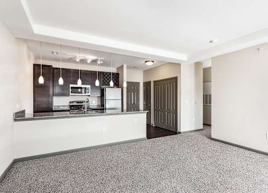 A kitchen with a refrigerator, microwave, and oven.