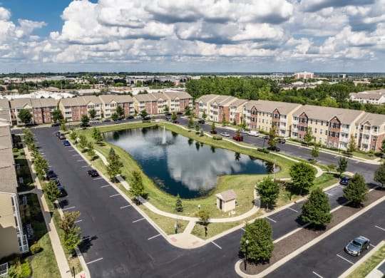 an aerial view of a pond in the middle of an apartment complex at The Avenue at Polaris Apartments, Ohio