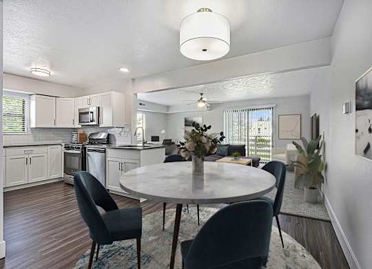 A modern kitchen with a dining table set for four at Byron Lakes Apartments in Byron Center, MI