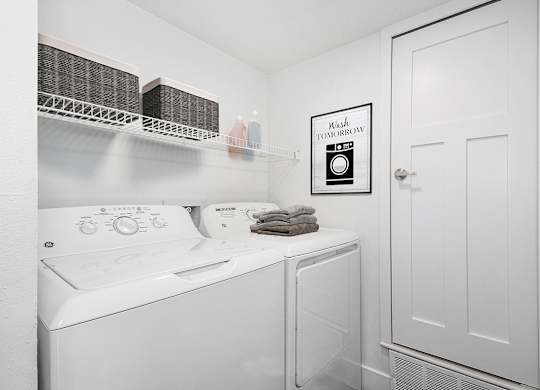 a laundry room with a washer and dryer at The Crossings Apartments, Michigan, 49508