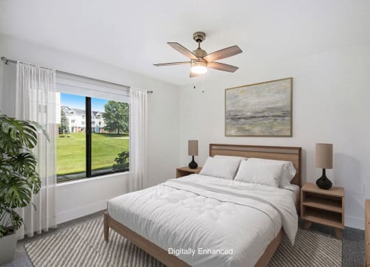 a bedroom with a bed and a ceiling fan and a window at The Crossings Apartments, Michigan, 49508