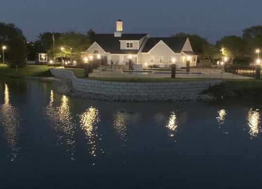 swimming pool and clubhouse at night overlooking as pond at The Crossings Apartments, Michigan