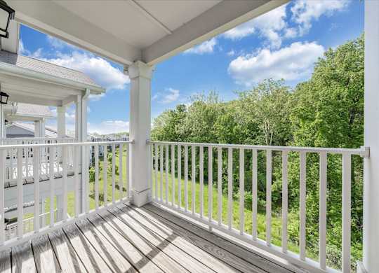 A white porch with a white railing and a view of trees at The Retreat Apartments, Roanoke, 24019