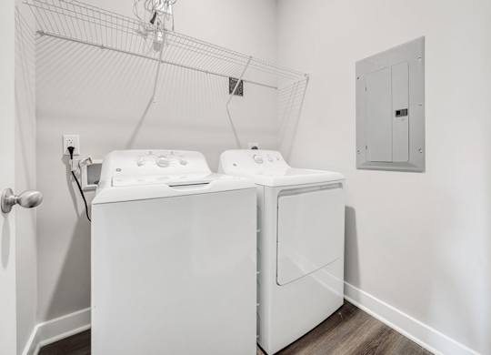 A white washing machine in a small laundry room at The Retreat Apartments, Roanoke, 24019