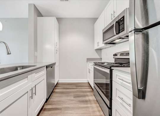 A modern kitchen with stainless steel appliances and white cabinets at The Retreat Apartments, Roanoke, 24019