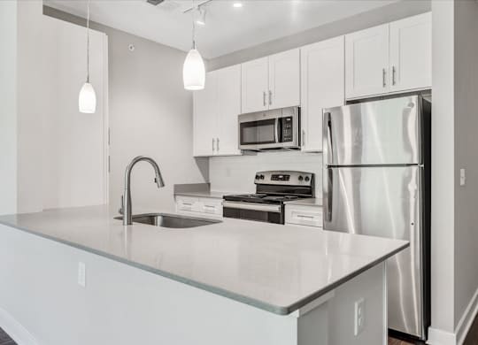 A modern kitchen with stainless steel appliances and white cabinets at The Retreat Apartments, Roanoke, 24019