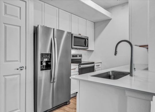 a kitchen with a sink and a refrigerator at The Vinings Apartments in Richmond, VA 