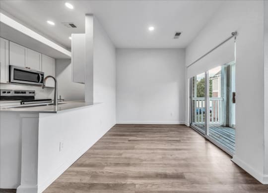 a kitchen with a counter and a door to a balcony at The Vinings Apartments in Richmond, VA 