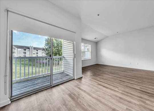 a living room with a sliding glass door to a balcony at The Vinings Apartments in Richmond, VA 23234