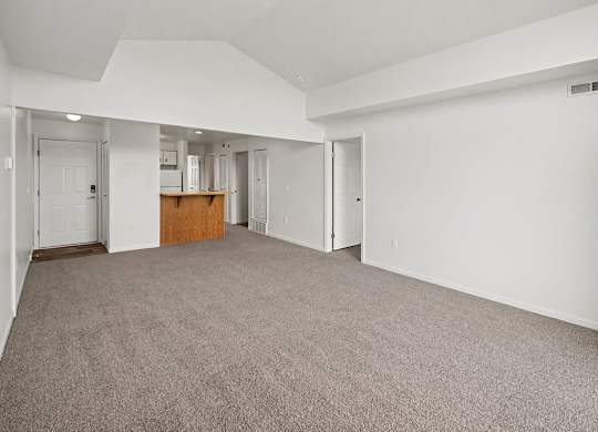 A large, empty dining room with a carpeted floor and white walls at Tracy Creek Apartments, Ohio