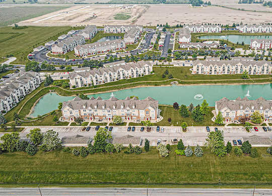 A large aerial view of an apartment complex with a pond in the middle at Tracy Creek Apartments, Perrysburg