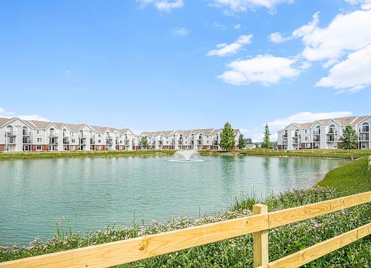 A row of apartments with a fountain in the middle of a pond at Tracy Creek Apartments, Perrysburg
