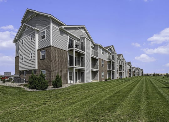 exterior of an apartment buildings with private patios and balconies at Trade Winds Apartment Homes in Elkhorn, NE 68022