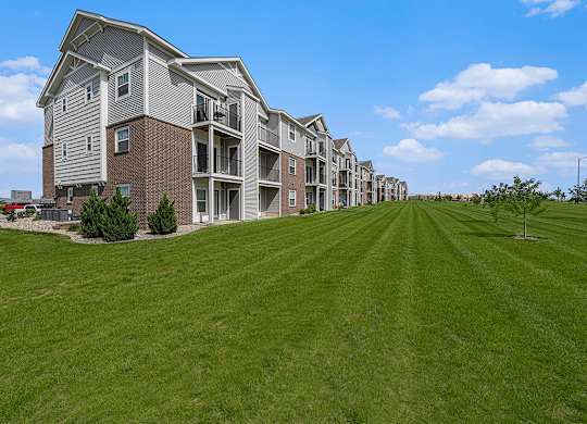 exterior of an apartment buildings with private patios and balconies at Trade Winds Apartment Homes in Elkhorn, NE 68022