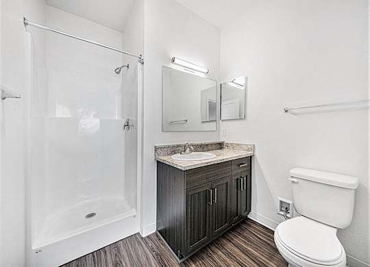a bathroom with a shower toilet and a sink at Trade Winds Apartment Homes in Elkhorn, NE 68022