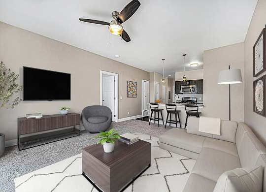 A living room with a grey armchair, a white sofa, a wooden coffee table, and a ceiling fan at Trade Winds Apartment Homes, Elkhorn, Nebraska