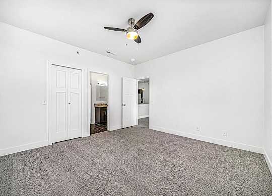 an empty bedroom with a ceiling fan at Trade Winds Apartment Homes in Elkhorn, NE 68022