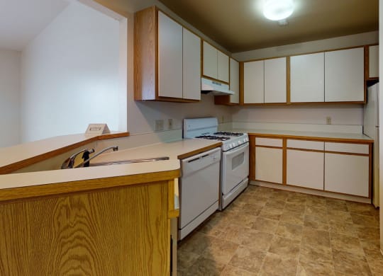 a kitchen with white appliances  at Trappers Cove Apartments, Lansing, MI, 48910