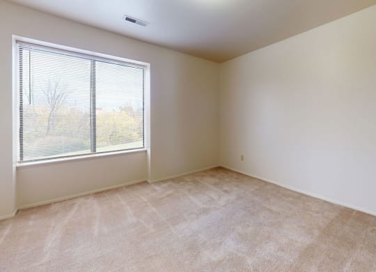 bedroom with a large window  at Trappers Cove Apartments, Lansing, 48910