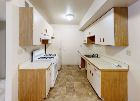 an equipped kitchen with white appliances  at Trappers Cove Apartments, Lansing, Michigan