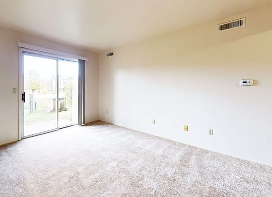 living room with a sliding glass door to a private patio at Trappers Cove Apartments, Michigan