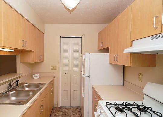 a kitchen with maple cabinetry at Trappers Cove Apartments, Lansing, 48910