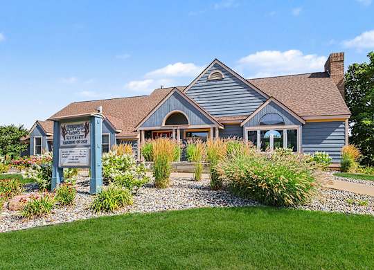 A leasing office and community building with a sign in front of it at Trappers Cove Apartments, Lansing, 48910