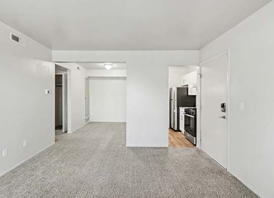 A spacious, empty dining room with a breakfast bar at Trappers Cove Apartments, Lansing