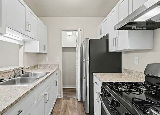 An upgraded gallery style kitchen with stainless steel appliances and a pantry at Trappers Cove Apartments, Lansing