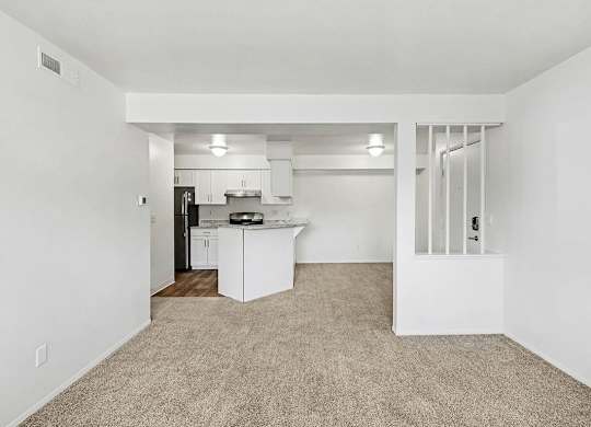 living and dining room with plush carpeting  at Trappers Cove Apartments, Lansing, MI