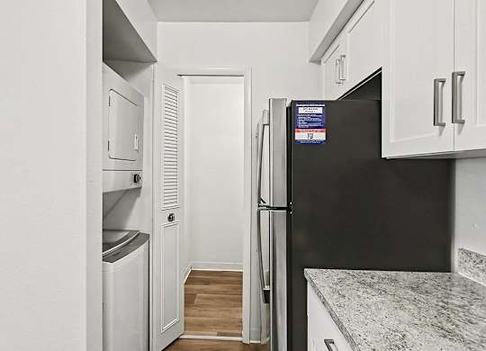 A kitchen with a washer and dryer and a pantry at Trappers Cove Apartments, Lansing