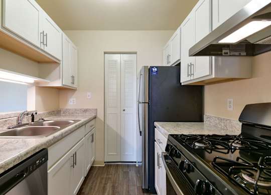 An upgraded kitchen with white shaker-style cabinets, stainless-steel appliances and a pantry at Trappers Cove Apartments, Lansing, 48910
