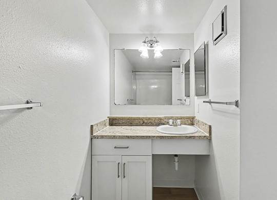An upgraded bathroom with a sink and mirror at Trappers Cove Apartments, Lansing