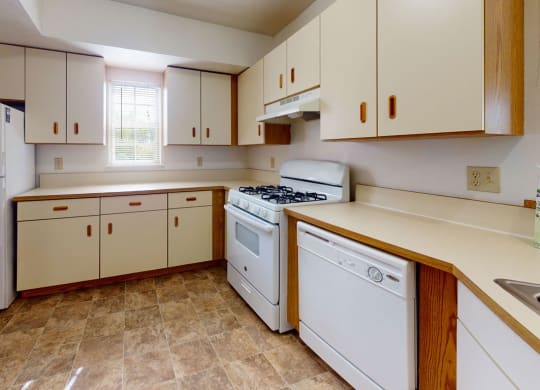 a kitchen with white appliances and a window at Trillium Pointe Apartment Homes, Jackson, 49201