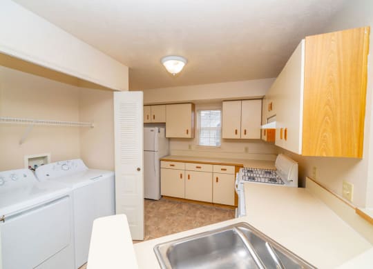a kitchen with a washer and dryer and a sink at Trillium Pointe Apartment Homes, Jackson, Michigan