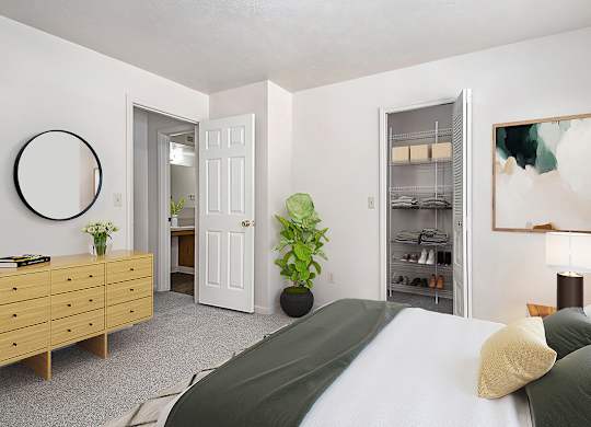 A bedroom with a bed, dresser, and a walk-in closet with wardrobe organizers at Trillium Pointe Apartment Homes, Jackson, MI