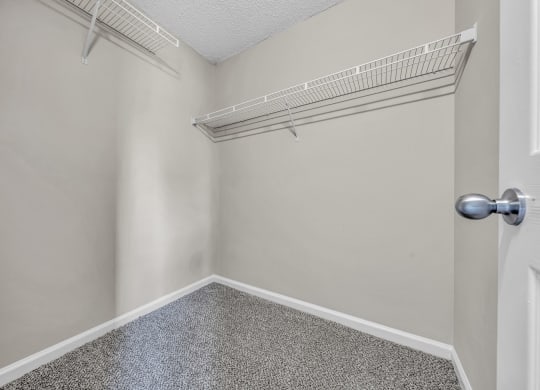 an empty closet with an open door and a shelf on the wall at Trophy Club at Bellgrade, Midlothian, VA, 23113